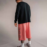 Model von hinten in roter 3/4 Shorts und schwarzem Longsleeve, Basketball-Streetwear von Tellem