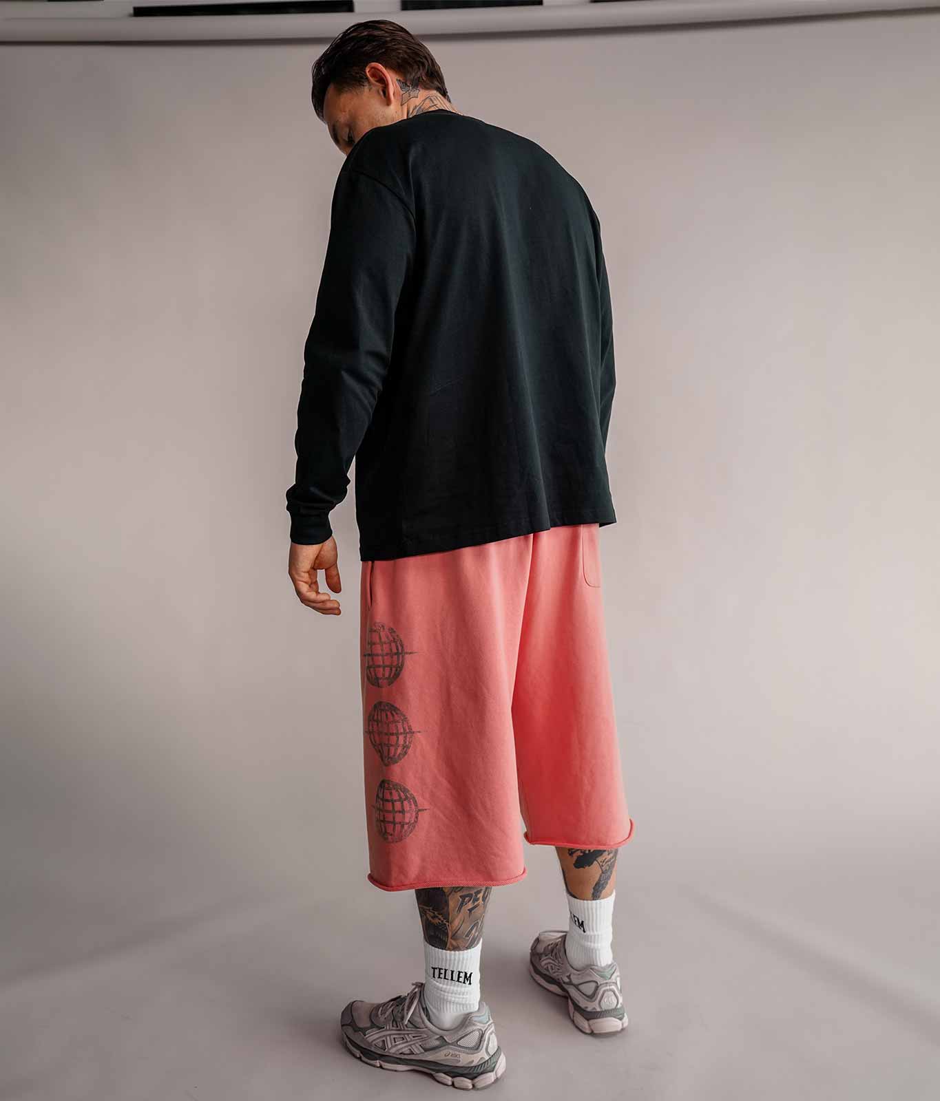 Model von hinten in roter 3/4 Shorts und schwarzem Longsleeve, Basketball-Streetwear von Tellem