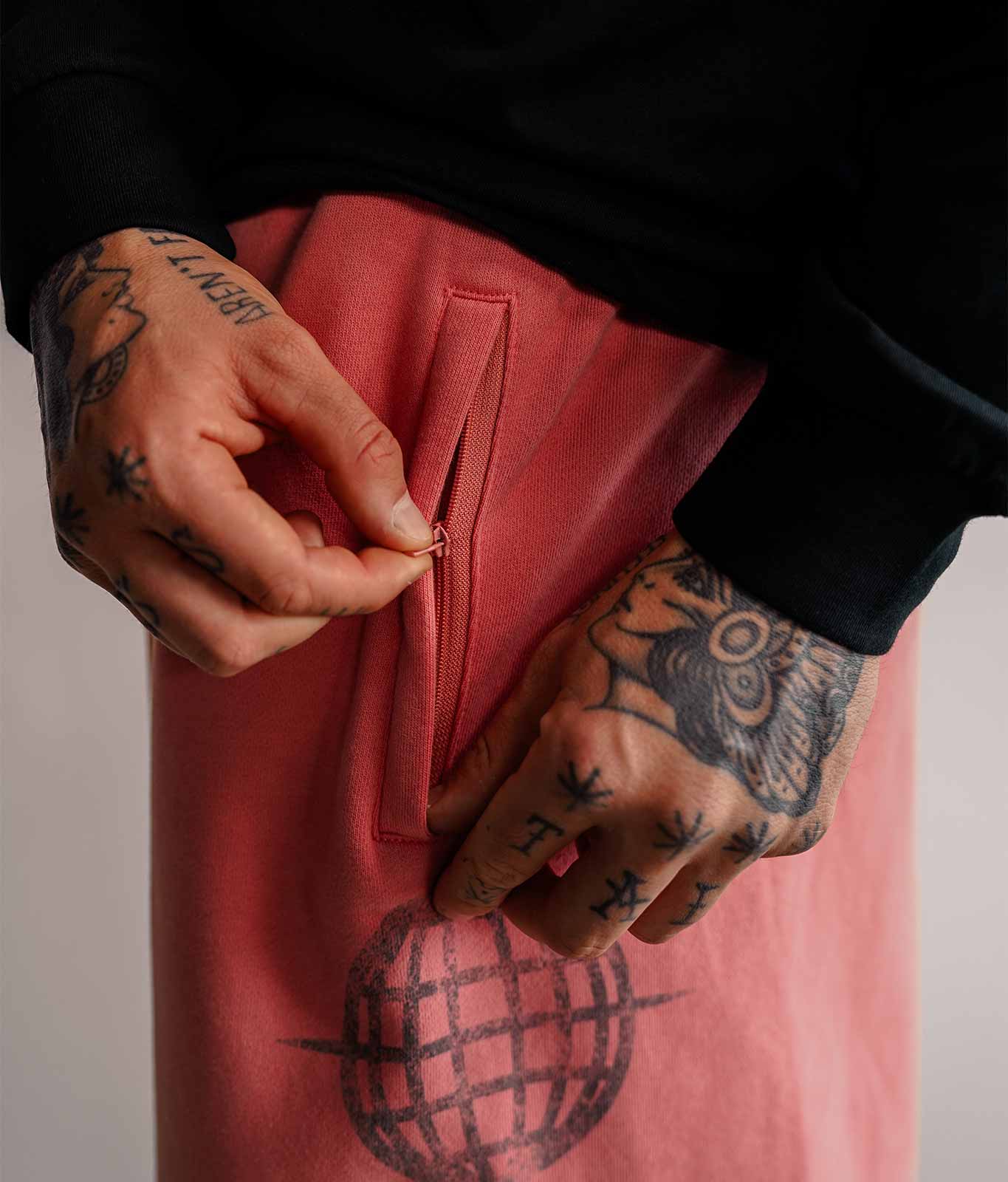 Nahaufnahme der Reißverschlusstasche Ton in Ton an roter 3/4 Sweatshorts