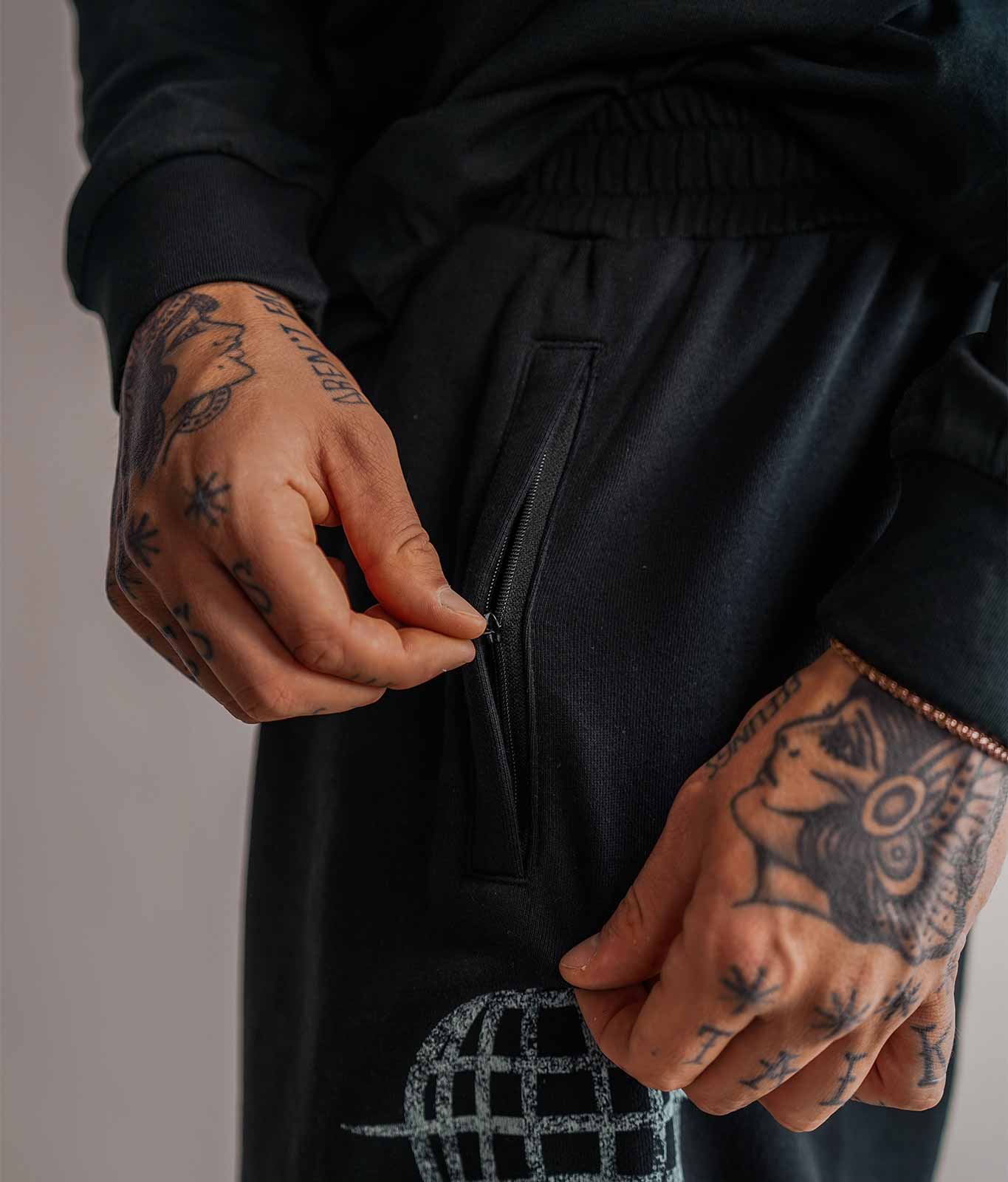 Nahaufnahme der Reißverschlusstasche Ton in Ton an schwarzer 3/4 Sweatshorts