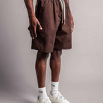 Model trägt die braune TELLEM Baumwoll Shorts aus Cotton Twill mit lockerem Fit.