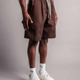 Model trägt die braune TELLEM Baumwoll Shorts aus Cotton Twill mit lockerem Fit.