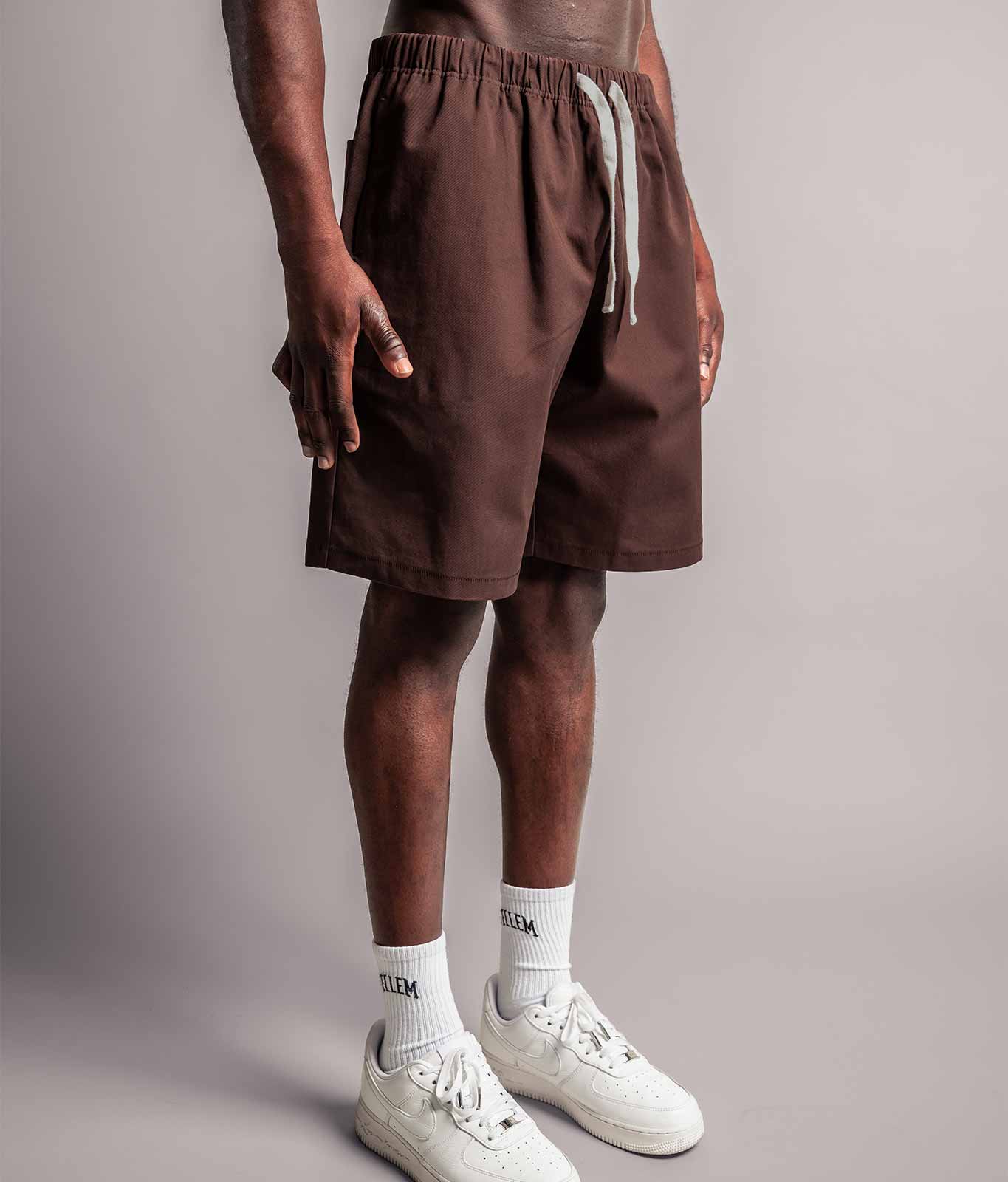 Model trägt die braune TELLEM Baumwoll Shorts aus Cotton Twill mit lockerem Fit.