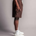 Model in seitlicher Ansicht trägt die braune TELLEM Baumwoll Shorts aus Cotton Twill mit lockerem Fit.