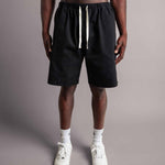 Model trägt die schwarzen TELLEM Baumwoll Shorts aus Cotton Twill mit lockerem Fit.