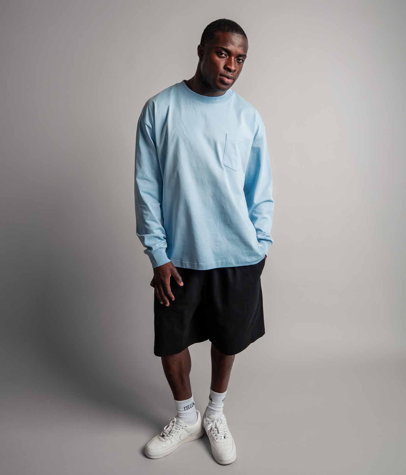 Model trägt TELLEM Longsleeve Pocket Ice Blau komplett mit Shorts, Frontansicht