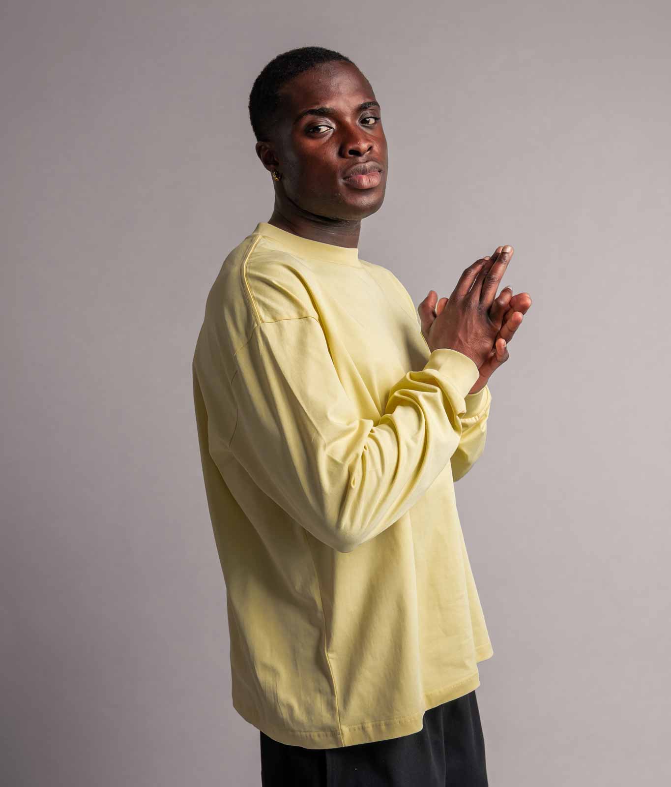 Model trägt TELLEM Longsleeve Pocket in Lemon Gelb, Seitenansicht mit Brusttasche