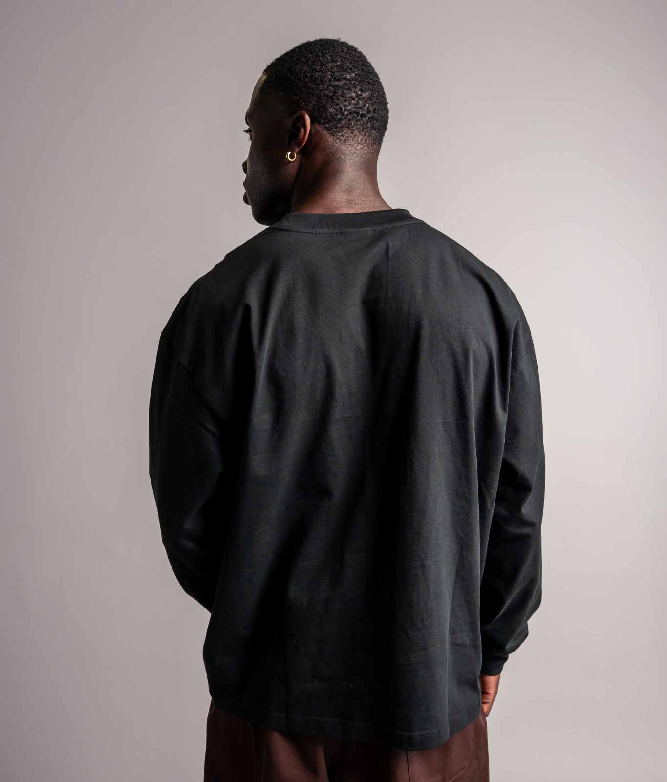 Rückenansicht vom schwarze TELLEM Longsleeve aus 100 % Baumwolle mit lockerem Fit.