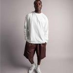 Model posiert im weißen TELLEM Longsleeve aus 100 % Baumwolle mit lockerem Fit.