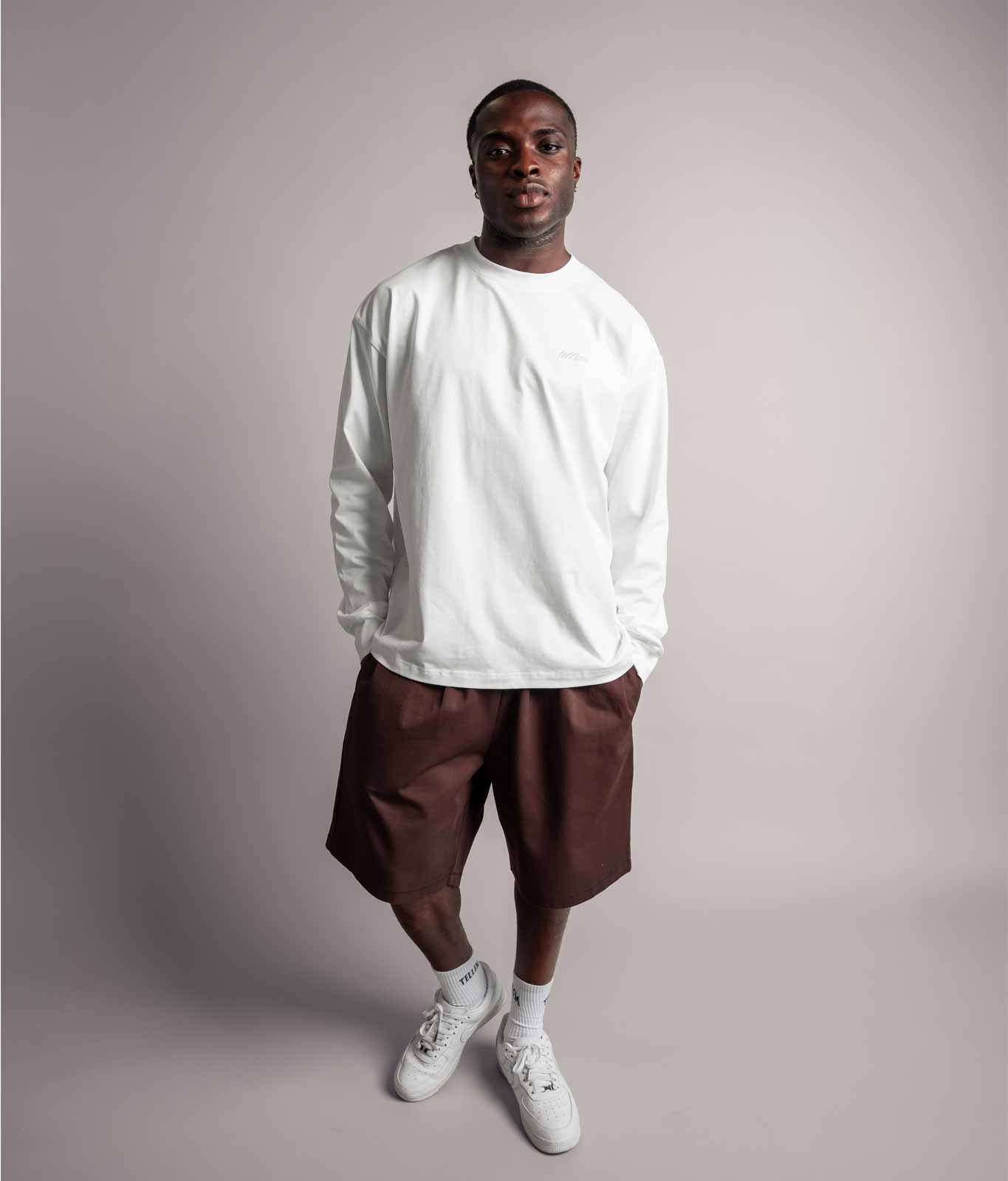 Model posiert im weißen TELLEM Longsleeve aus 100 % Baumwolle mit lockerem Fit.