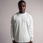 Model trägt das weiße TELLEM Longsleeve aus 100 % Baumwolle mit lockerem Fit.