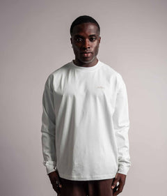 Model trägt das weiße TELLEM Longsleeve aus 100 % Baumwolle mit lockerem Fit.